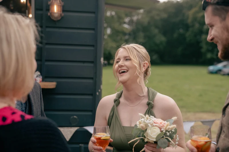 A bridesmaid laughing at Alice and Alex’s drinks reception