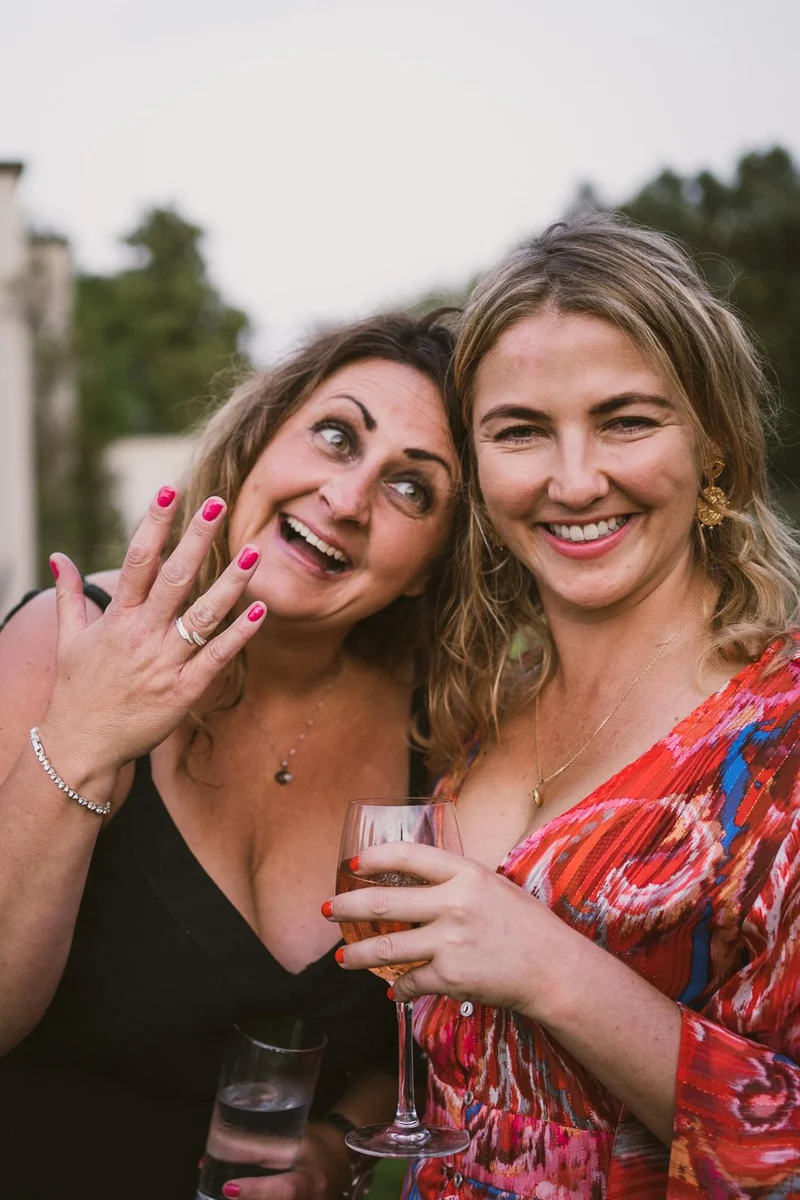 Two guests laughing together at Rhea and Ben’s wedding