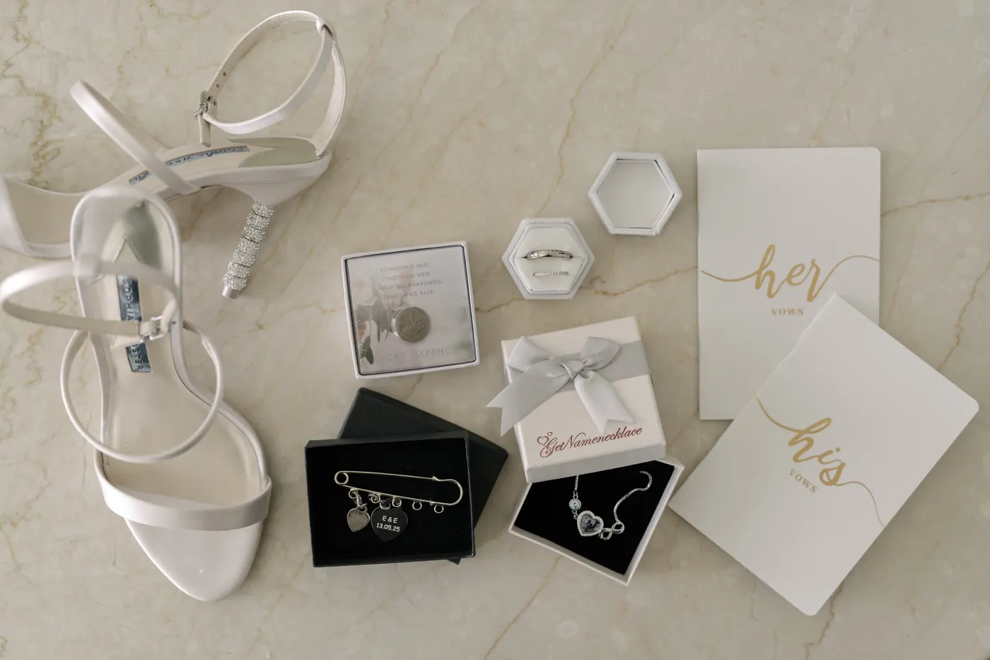 Bridal sandals, jewellery boxes and his and hers vow books laid out together