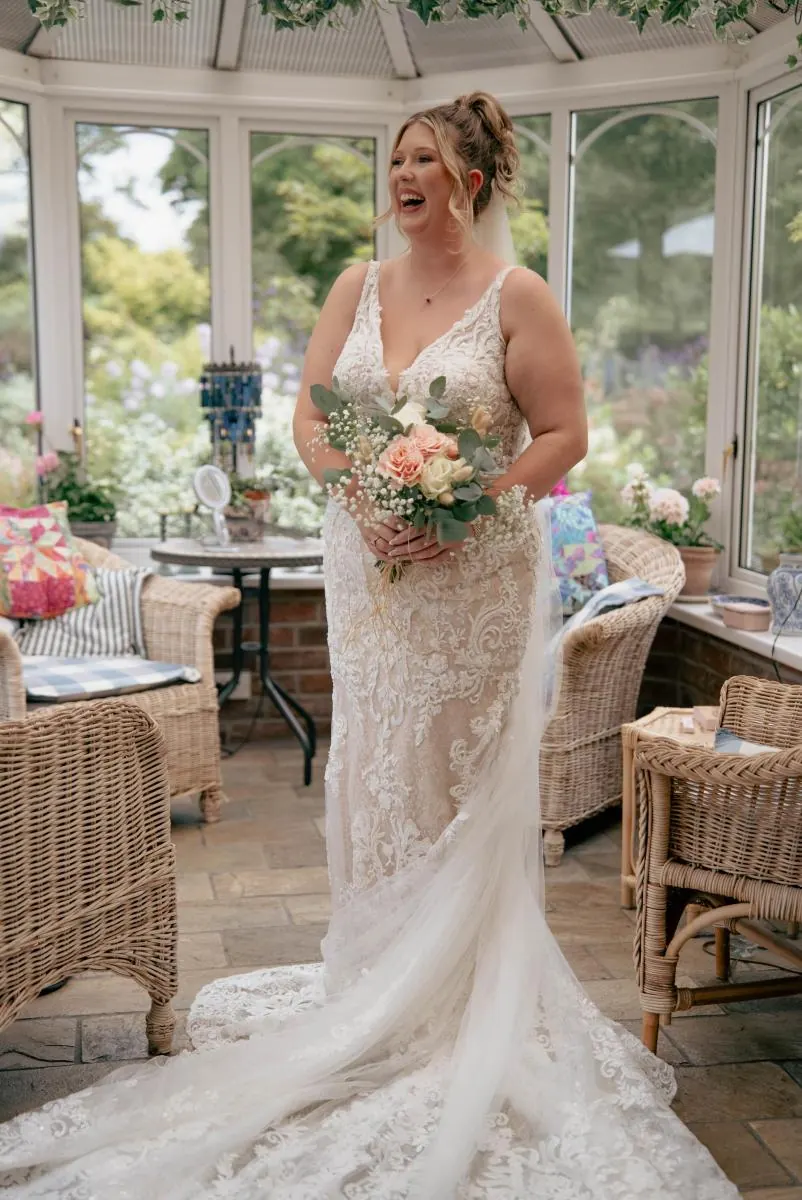 Bride holding her bouquet in a sunny conservatory