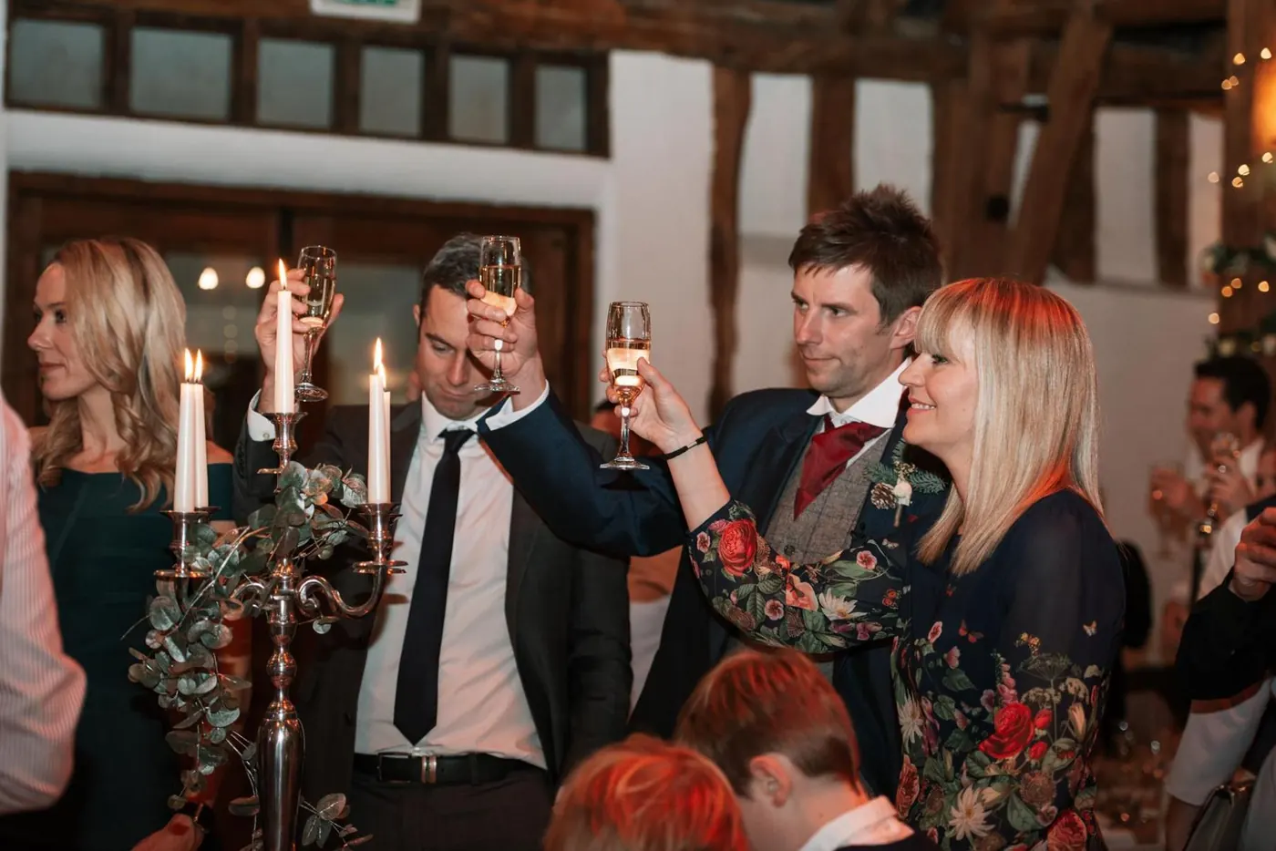 Guests raising a toast by candlelight