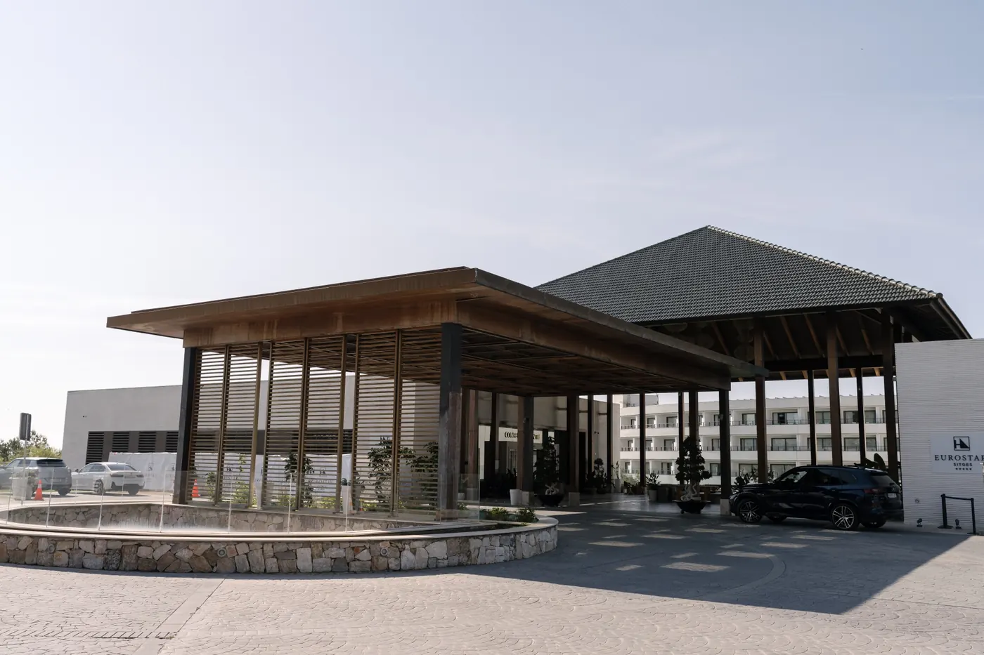 Modern hotel entrance with a timber canopy on a bright wedding morning