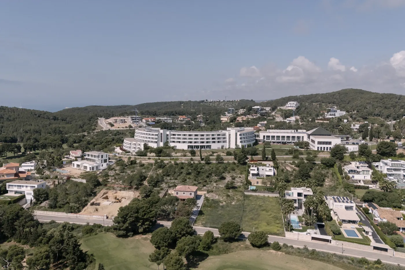 Aerial view of a hotel wedding venue set among green hills on the Spanish coast
