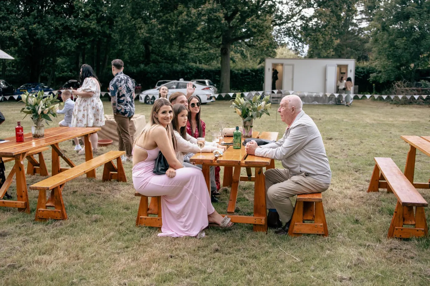 Guests relaxing at picnic tables on the lawn