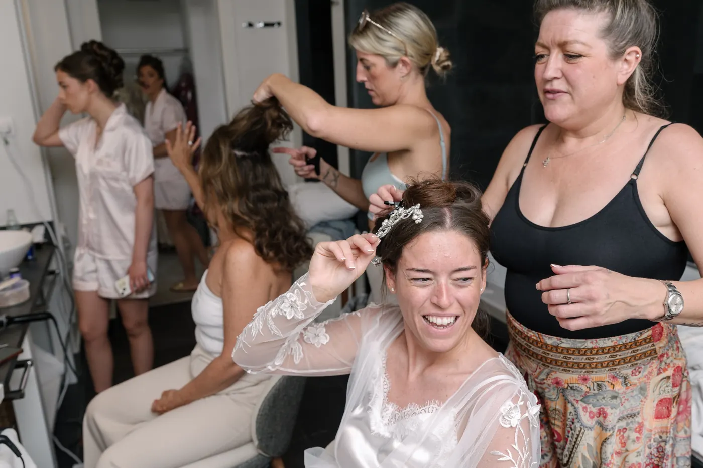 Bridesmaid laughing while her hair is styled