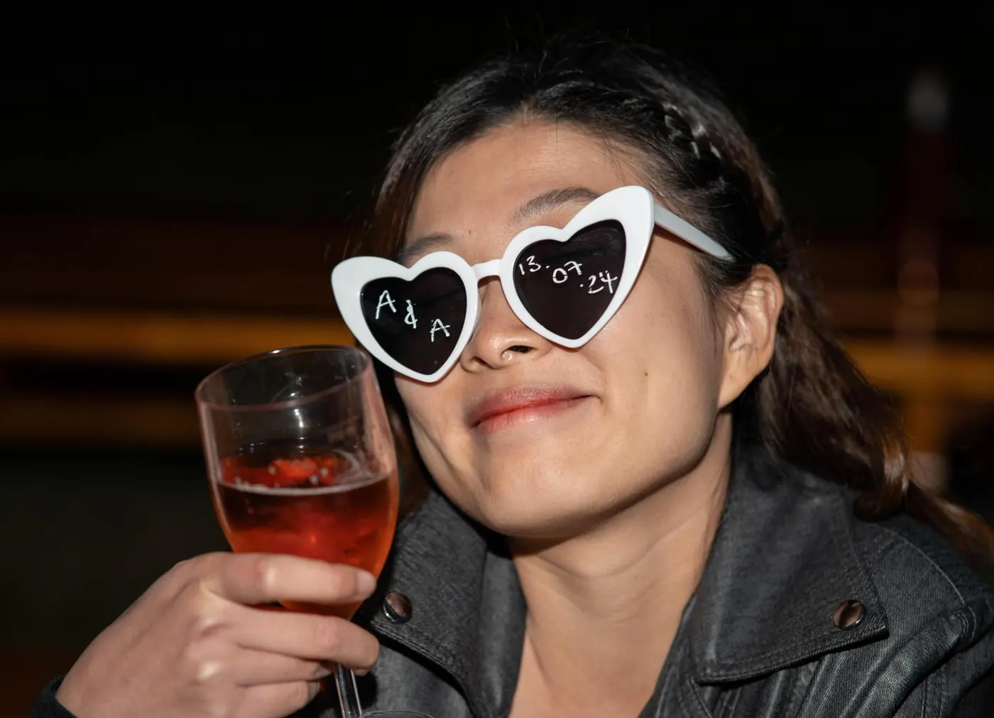 Guest in heart-shaped sunglasses raising a glass