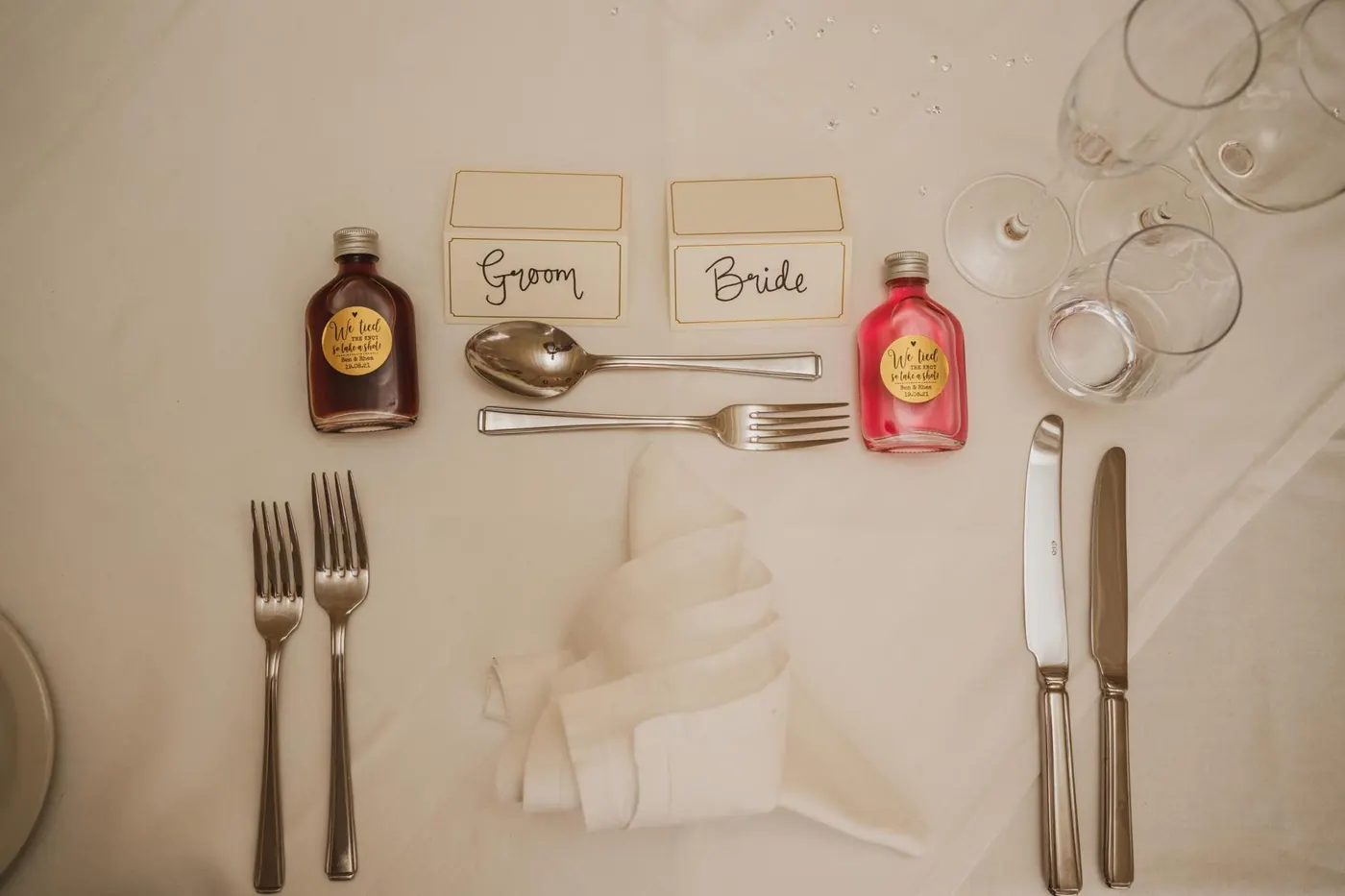 Place setting with name cards and miniature liqueur favours