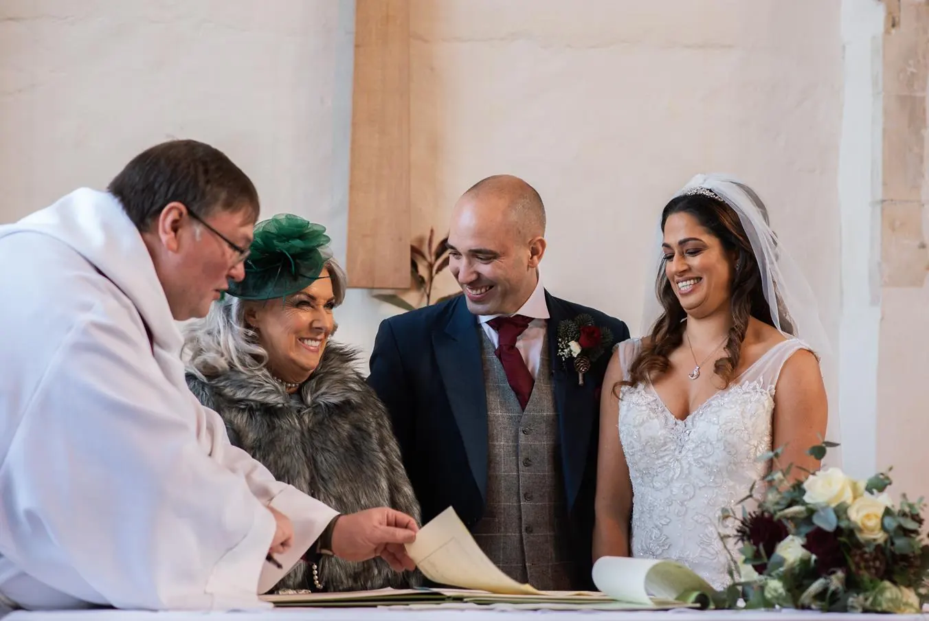 Couple signing the marriage register with the vicar
