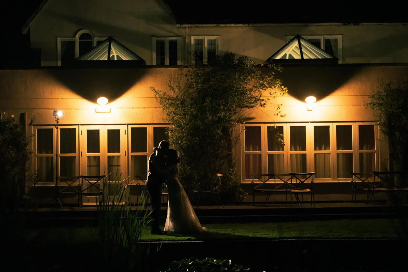 Couple silhouetted outside the lit-up venue at night
