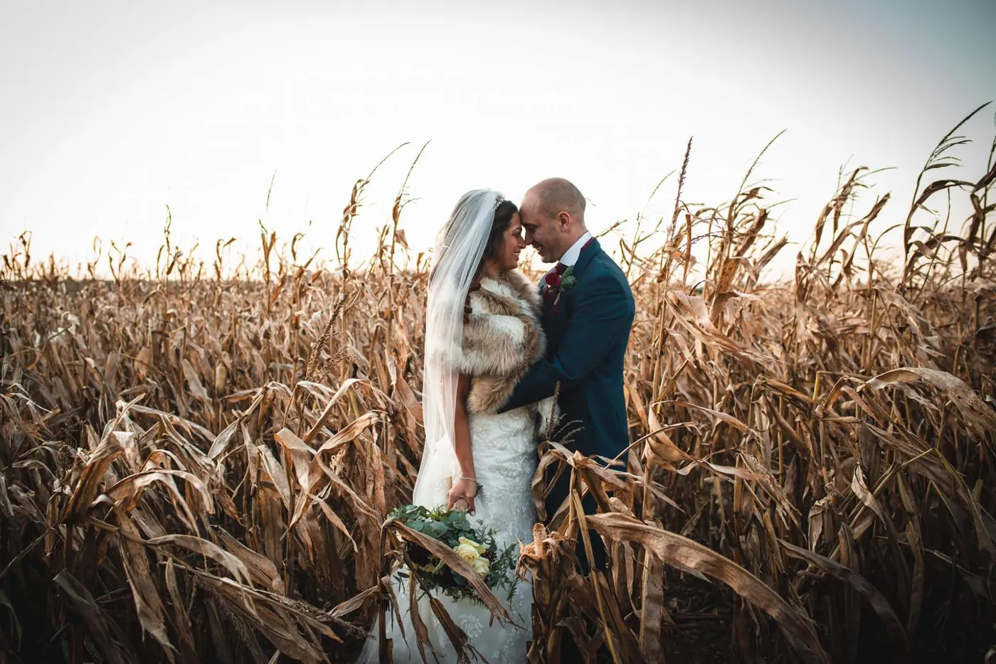 Couple in a winter cornfield at sunset
